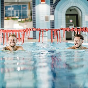 HofBad Schwimmerbecken Grafik: Zwei Männer ziehen Bahnen im Schwimmerbecken